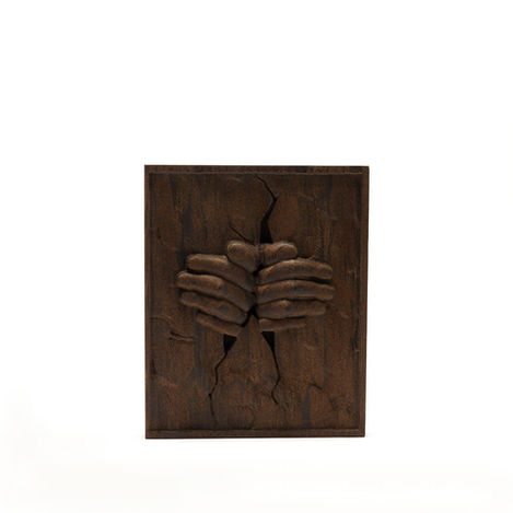 a wood carving of two hands holding each other