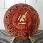 a wooden clock with a celtic design on it