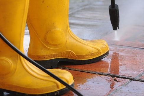 person-wearing-yellow-rubber-boots-with-high-pressure-water-nozzle-cleaning-dirt-tiles.jpg