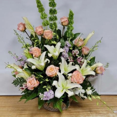 Peach rose and white lily garden arrangement with bells of Ireland