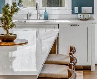 Modern kitchen island with bonsai plant and bar stools