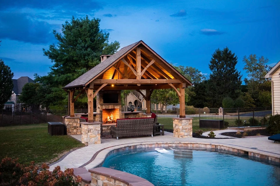 White-trimmed pool cabana with a cupola and weathervane, wraparound sectional seating on a stone patio poolside