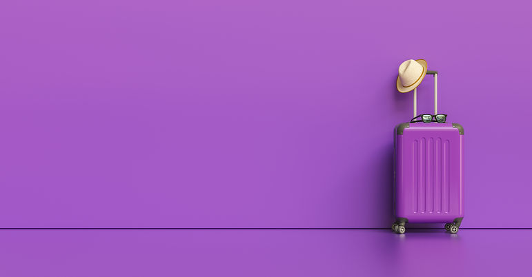 Suitcase with hat and sunglasses on purple background. travel concept, with copy space for