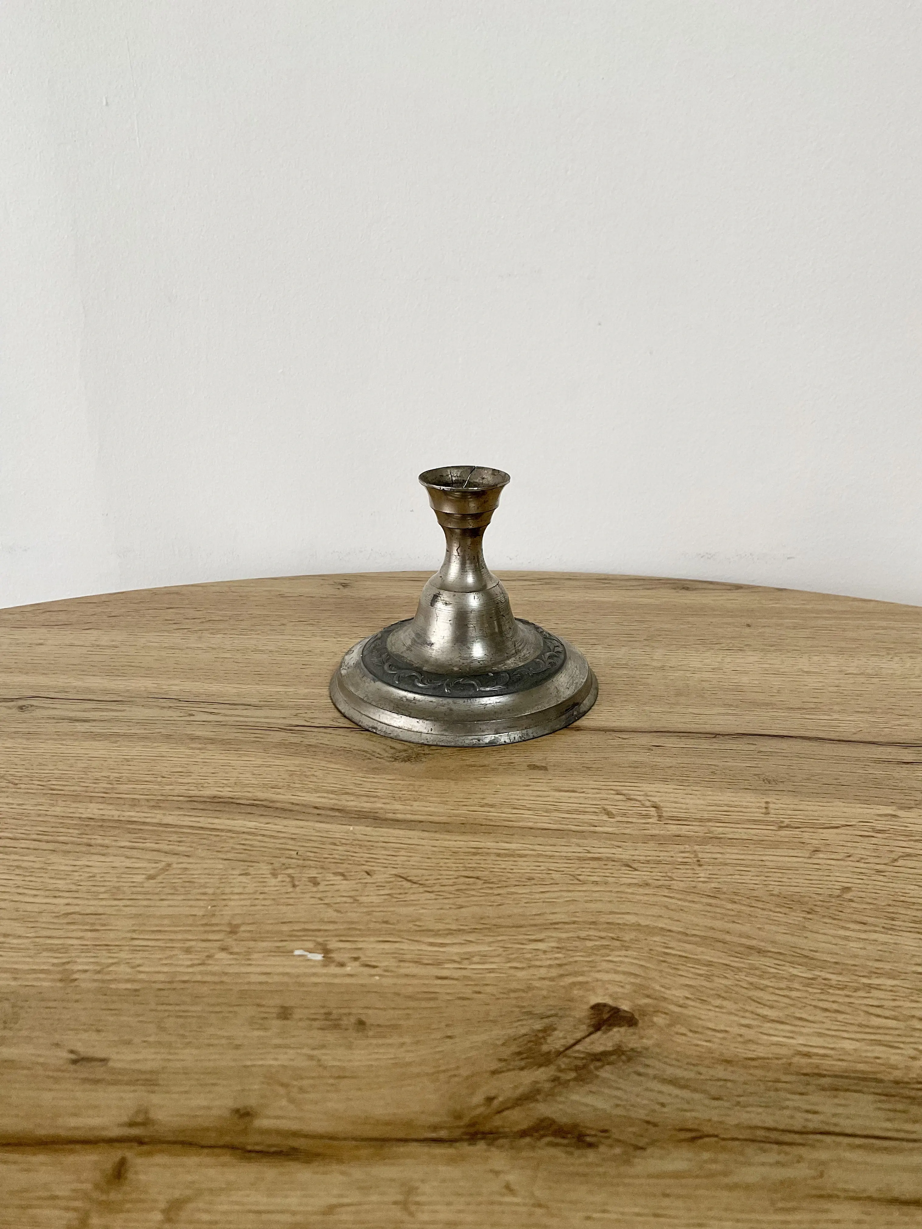 bougeoir médiéval en argent posé sur une table en bois