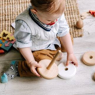 little boy playing with wooden toys