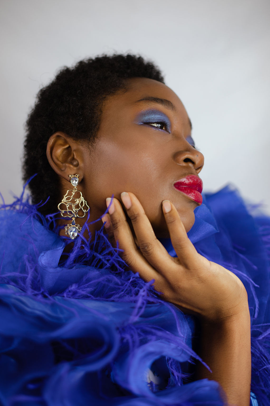 Model in cobalt blue ruffled top, red lips — editorial by Mady