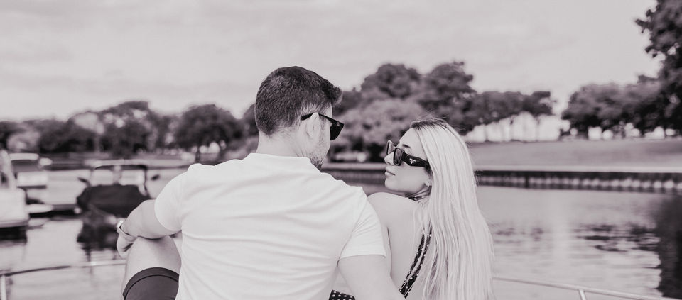 Couple on boat. Man and woman in sunglasses, water and trees in background couple photography chicago.