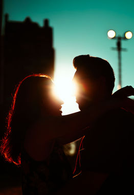 Couple embracing in silhouette, sun shining between them; couple photography Chicago.