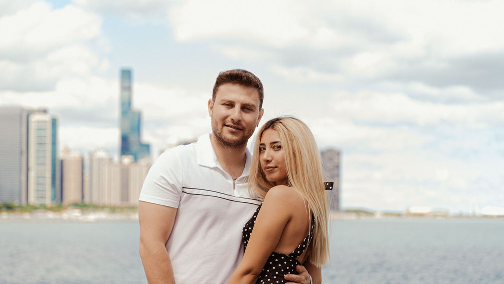 Couple posing together, Chicago cityscape in the background; couple photography Chicago.