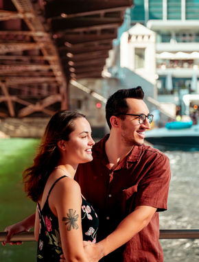 Couple smiles on a bridge in Chicago with bright background, couple photography Chicago.