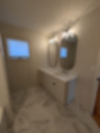 inside a double sink bathroom showing sinks and floor tile and window