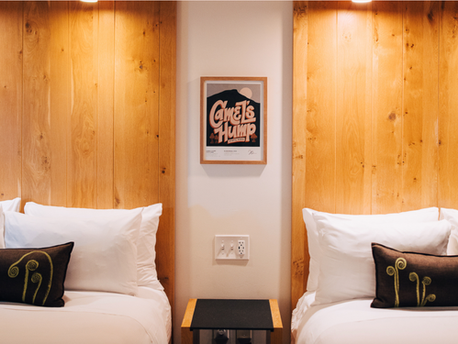 Two hotel beds with Camel's Hump State Park artwork on the wall between them 