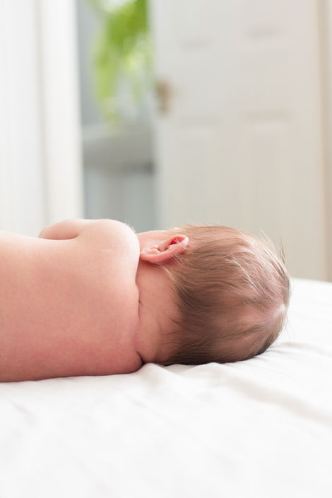 a baby laying on its back with its ear visible