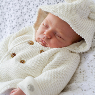 sleeping baby lying on white blanket