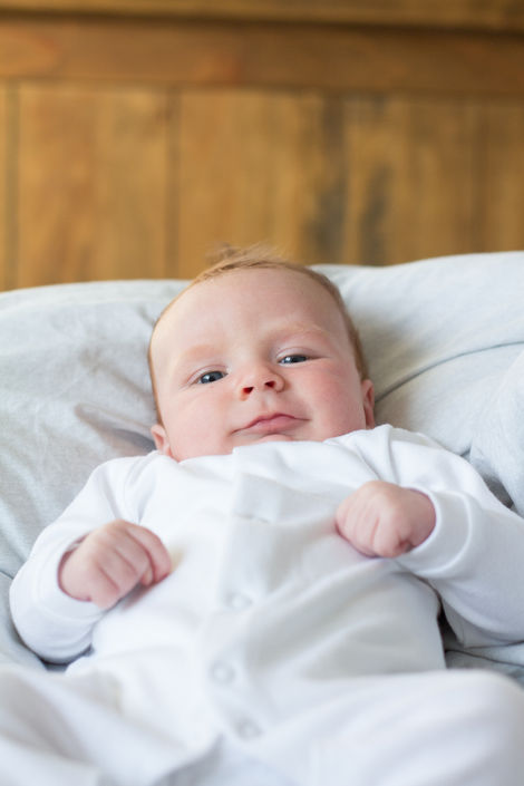 a baby in a white vest is laying on a bed