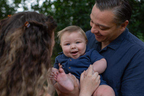 parents cuddle baby boy in blue