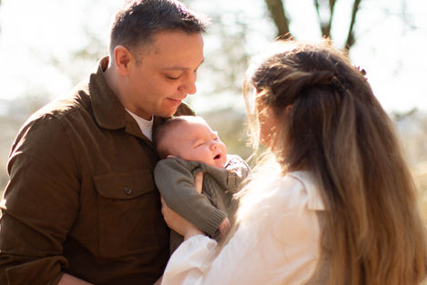 dad holding baby son, facing mum