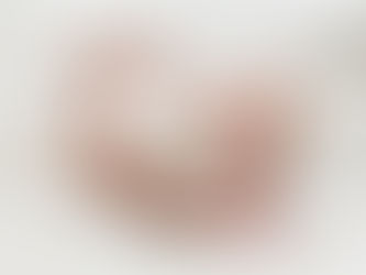 newborn baby sleeping on a white sheet, wearing a cream baby grow with stars