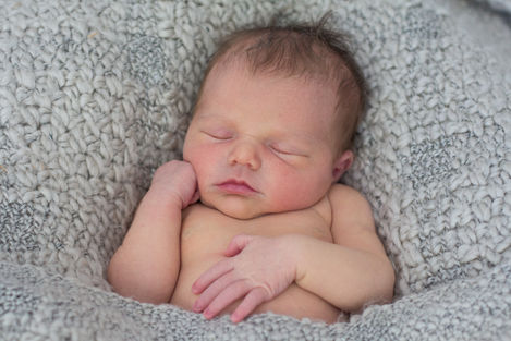 a newborn baby is sleeping in a knitted blanket