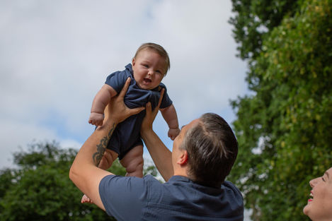 dad lifts baby into the air