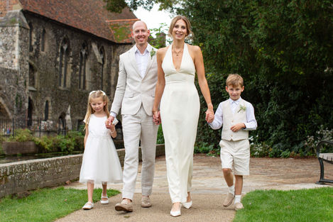 Family walking together in formal attire outdoors.