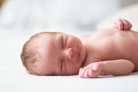 a newborn baby is sleeping on a white blanket