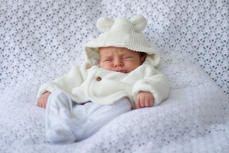 a baby is wearing a white jumper with ears on the hood