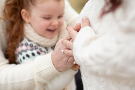 a little girl is holding a woman 's hand and smiling