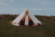 bell tent with a wedding dress in the doorway
