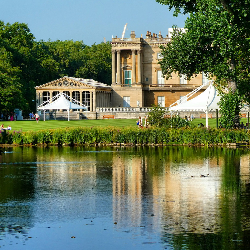 The lake at Buckingham Palace with the palace and a white marquee reflected in the still water
