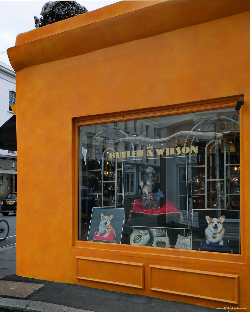 The bright orange shopfront of Butler & Wilson on Fulham Road, with gold lettering on the window and a Halloween display inside