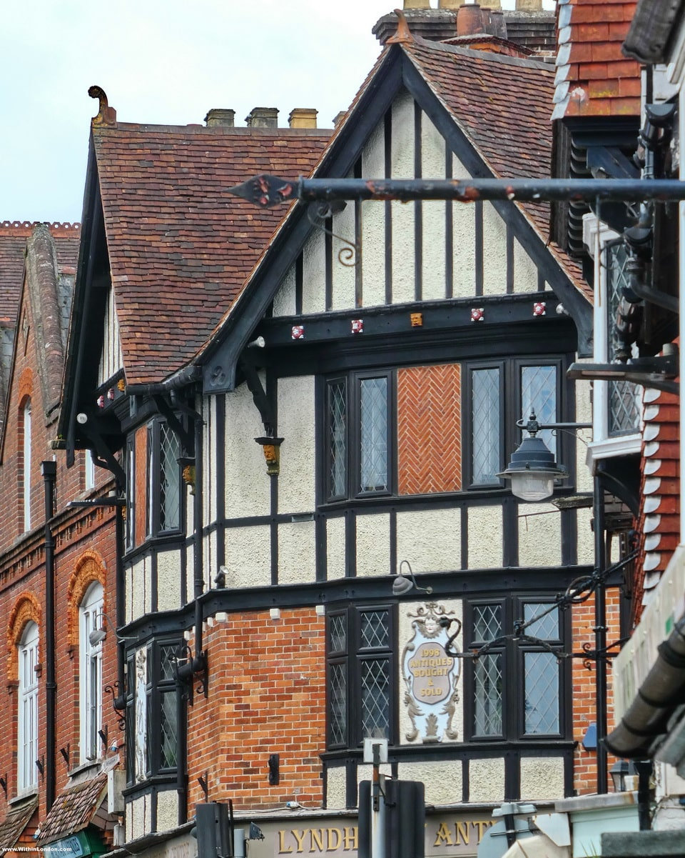 A black-and-white timbered building with red brick and leaded windows on Lyndhurst High Street