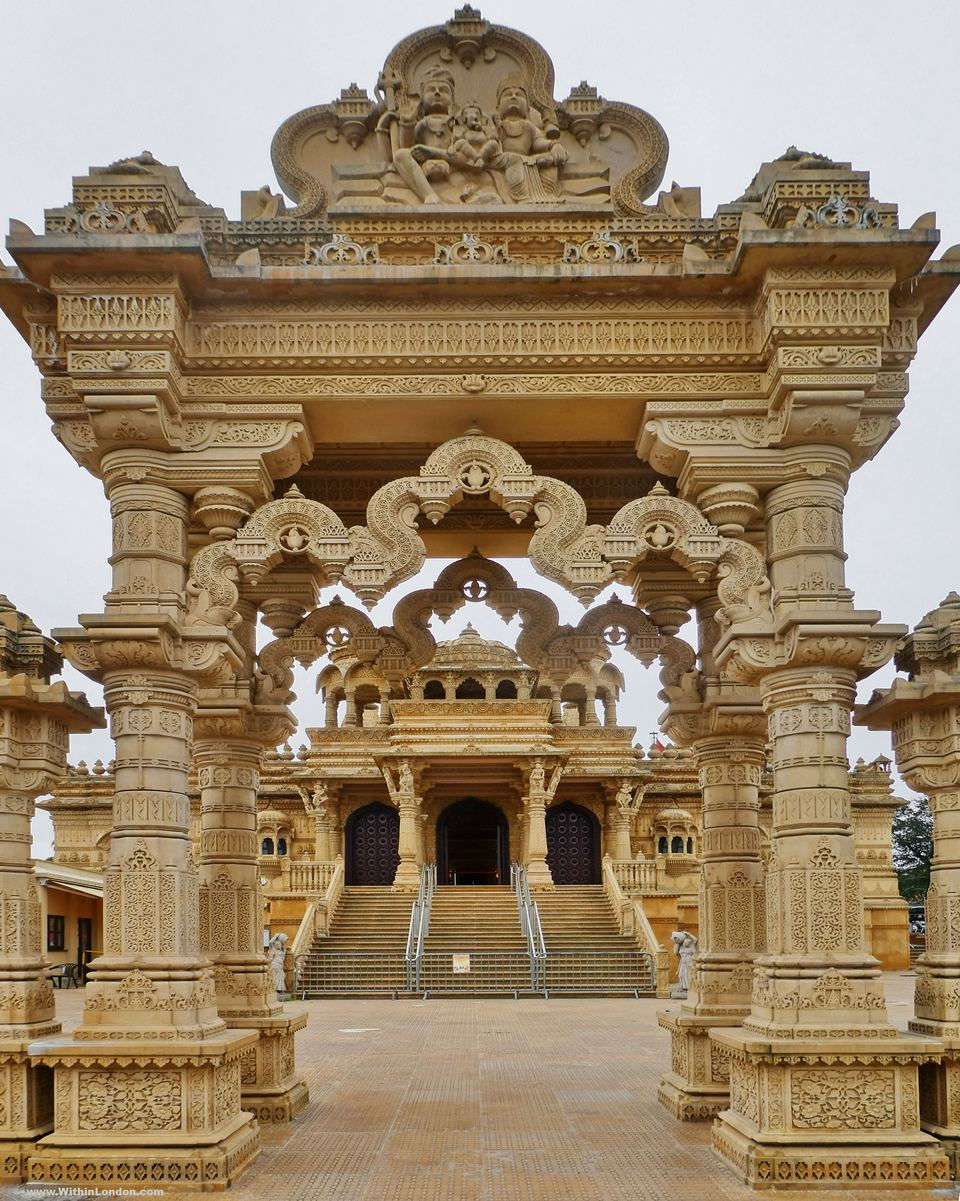 The carved stone torana archway at Shree Sanatan Hindu Mandir in Wembley, framing the steps up to the temple