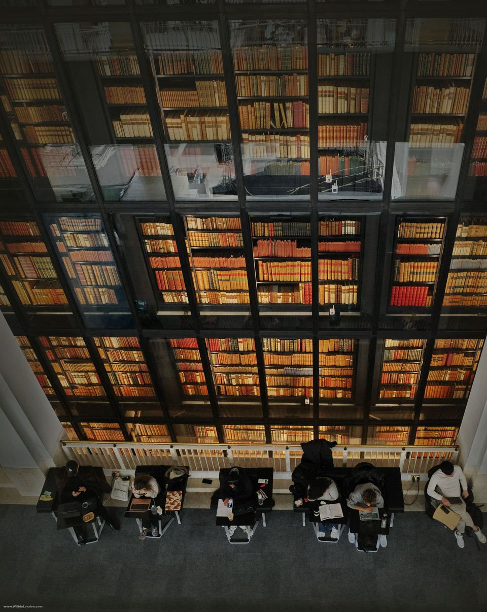 The King's Library tower at the British Library, six glass walled storeys of leather bound books, with readers at desks along its base