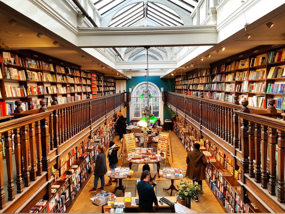 The oak-galleried back room of Daunt Books Marylebone, lit by its long skylight, with book-lined walls running the length of the room