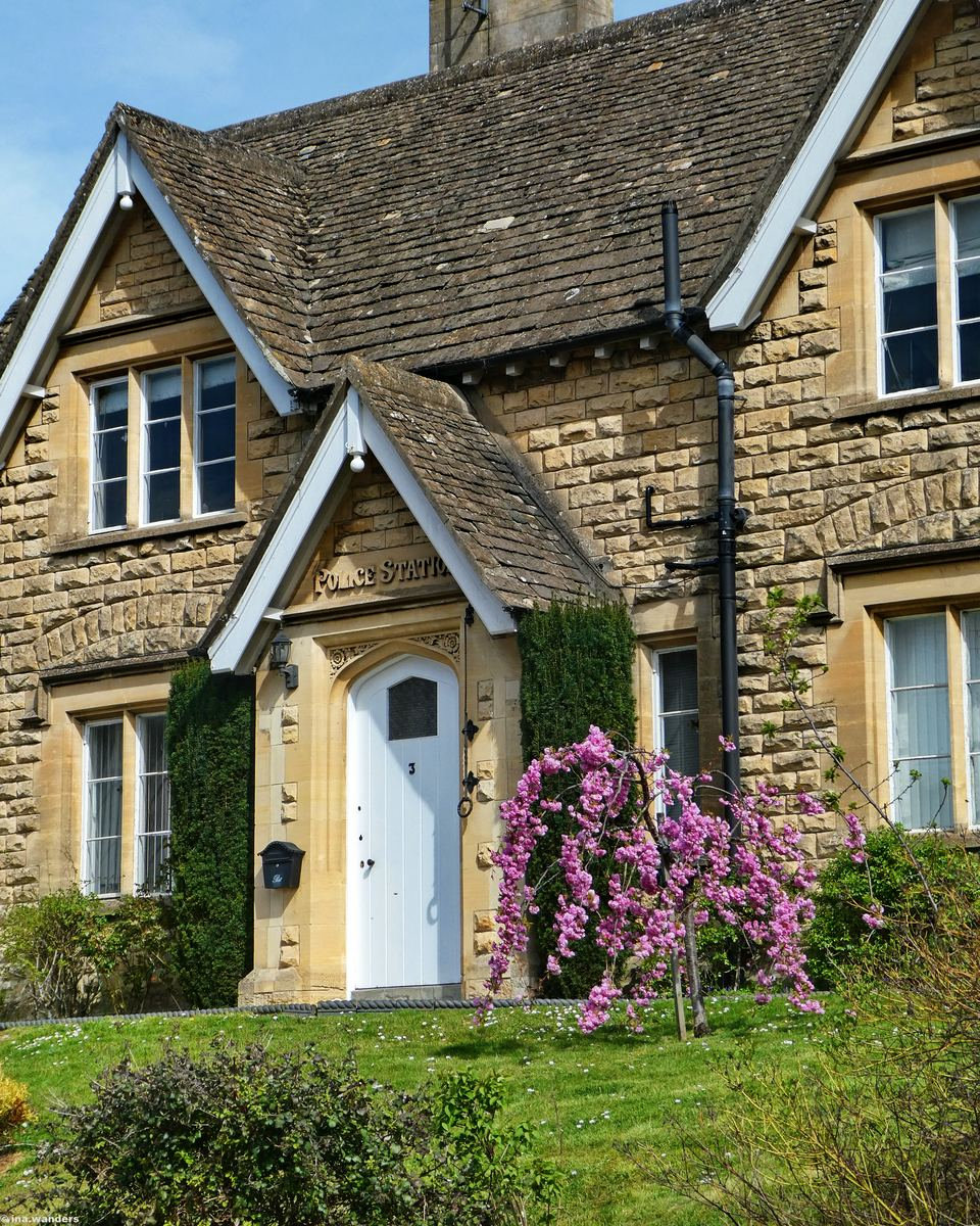 The old police station cottage in Winchcombe framed by spring blossom