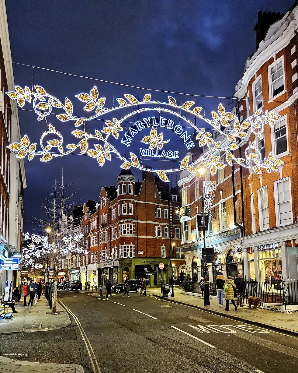 An illuminated Marylebone Village sign strung across Marylebone High Street at Christmas