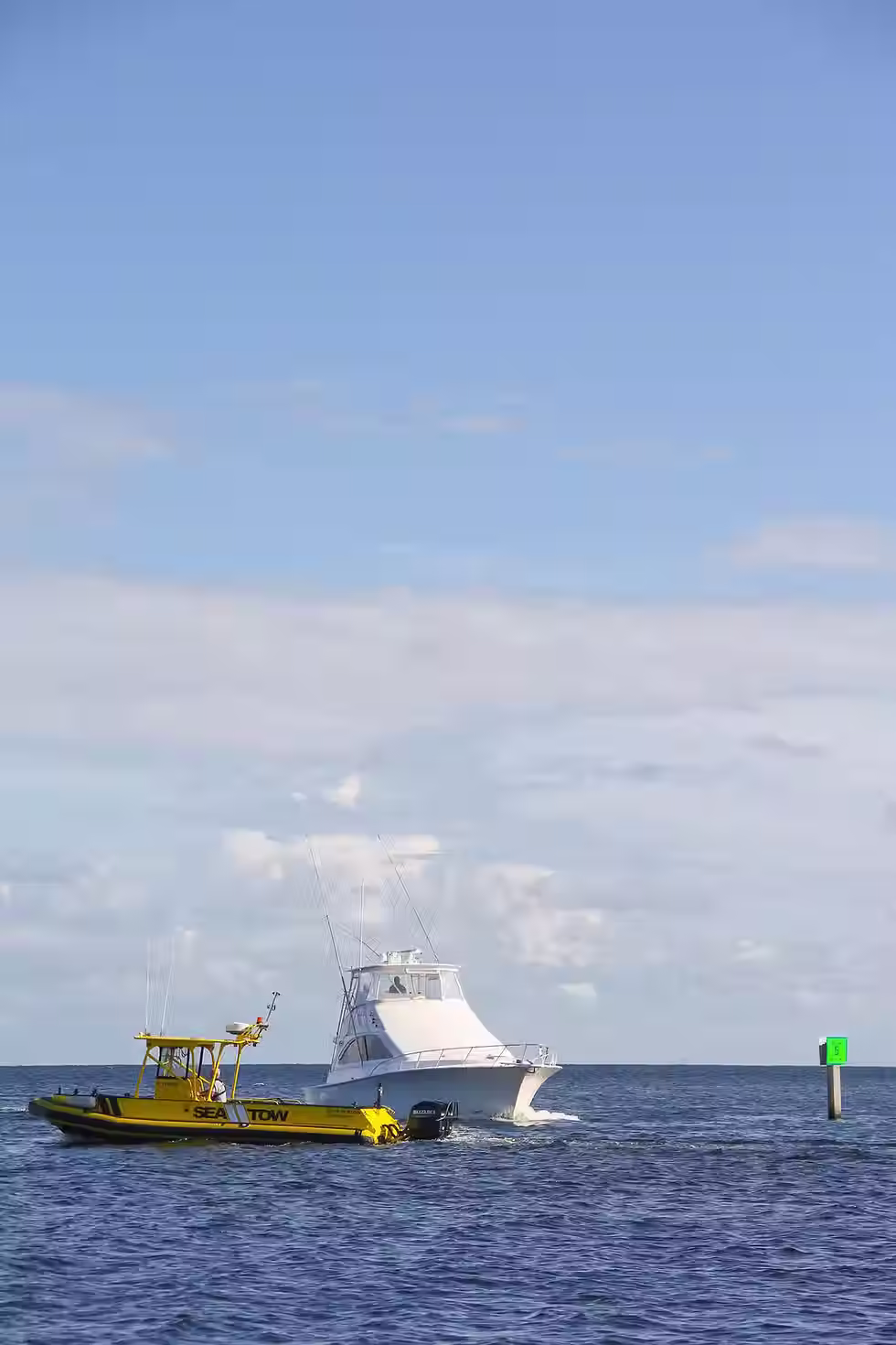 Barco de asistencia marítima realizando un remolque a un velero civil averiado tras sufrir daños en el timón.