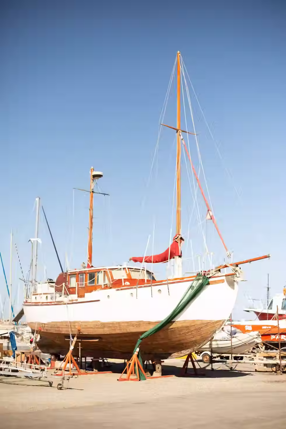 Mecánicos náuticos revisando y reparando la pala del timón de un velero en un astillero de varadero.