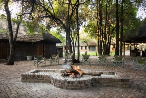 An outdoor fireplace at the lodge, with comfortable rooms partially visible behind it.