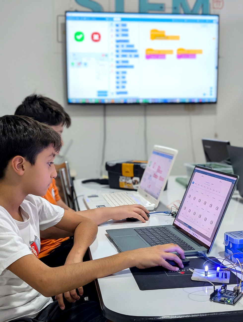 Eye-level view of a child programming a robot during a workshop