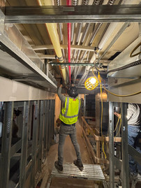 Crew member preparing slab surface for carbon fiber reinforcement installation during Aladdin Hotel renovation in Kansas City.