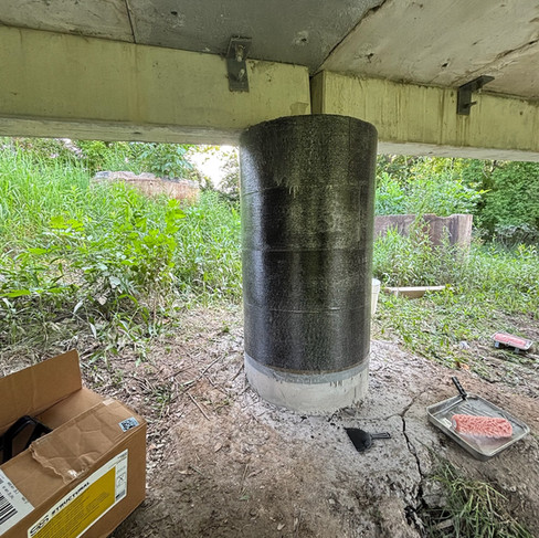 CFRP-wrapped bridge column reinforced for durability, prepared for protective coating under a bike path bridge