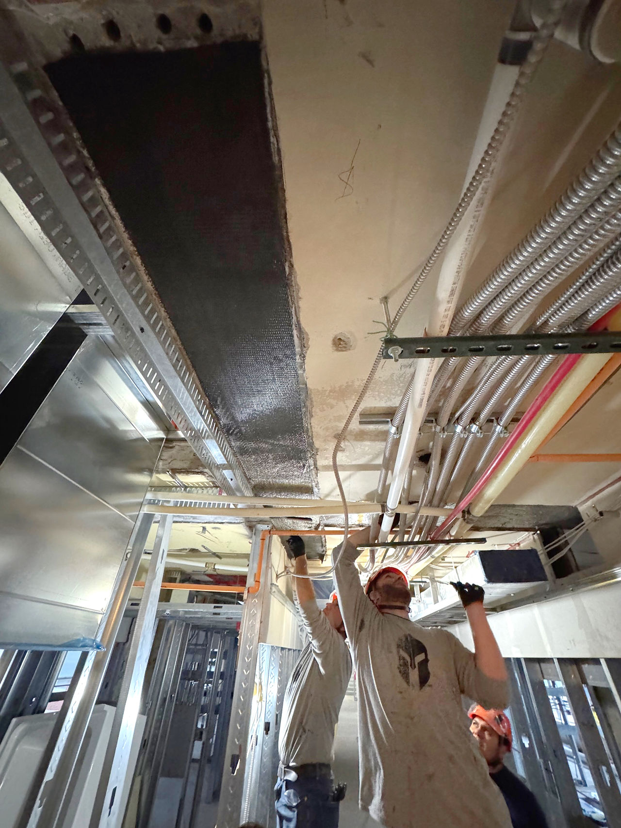 Carbon fiber strap installed along slab edge during structural strengthening at the Aladdin Hotel renovation in Kansas City.