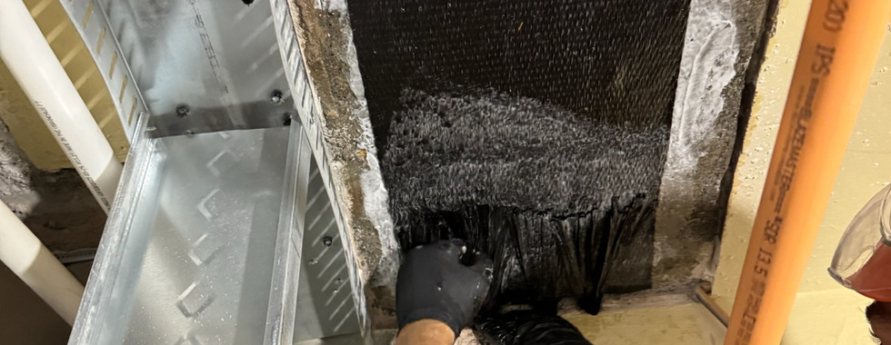 Worker installing splayed anchors into slab edge after carbon fiber strap placement, part of structural strengthening at the Aladdin Hotel