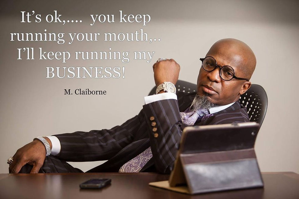 Michael Claiborne sitting at a brown desk in a suit with a Ipad and phione 