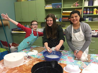 three students making paper mache