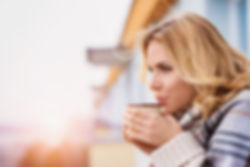 Blonde woman blowing on coffee