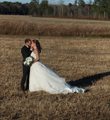 Married couple kissing in an open field