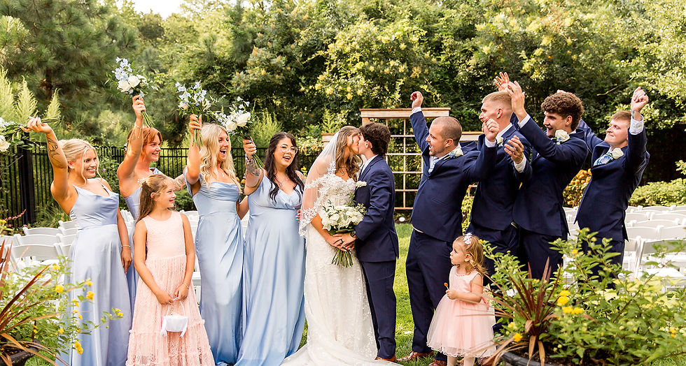 Couple kissing surrounded by their wedding party in Vienna Maryland, at a secret garden